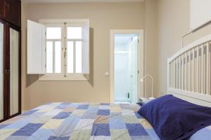 a bedroom with a bed with a quilt on it at Dream Vacation at Casa Vicki in Almería