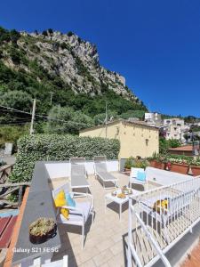 a patio with chairs and a table and a mountain at Casetta a Nerano in Nerano