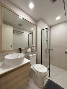a bathroom with a toilet and a sink and a shower at The Bahamas & Maldives Suites at Azure Residences near Manila Airport in Manila