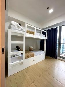 a bedroom with two bunk beds in a room at The Bahamas & Maldives Suites at Azure Residences near Manila Airport in Manila
