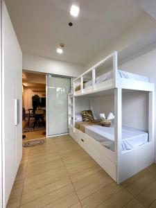 a bedroom with two bunk beds in a room at The Bahamas & Maldives Suites at Azure Residences near Manila Airport in Manila