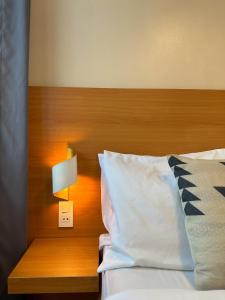 a bed with a wooden head board and a lightswitch at The Bahamas & Maldives Suites at Azure Residences near Manila Airport in Manila