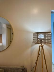 a lamp in front of a wall with a mirror at The Bahamas & Maldives Suites at Azure Residences near Manila Airport in Manila