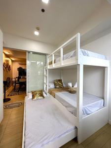 two bunk beds in a room with a piano at The Bahamas & Maldives Suites at Azure Residences near Manila Airport in Manila