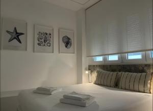 a white bedroom with a bed with two towels on it at Apartments Vent de Vela in Valencia +136 photos