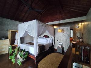 a bedroom with a white bed with a canopy at Beachfront Villa Tara Bliss Candidasa in Candidasa