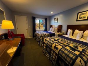a hotel room with two beds and a desk at American Boutique Inn - Lakeview in Mackinaw City +79 photos