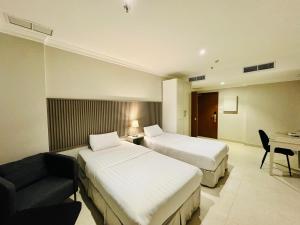 una camera d'albergo con due letti e un divano di Times Square Suite Hotel a Kuwait