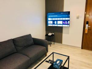 un soggiorno con un divano e una TV di Times Square Suite Hotel a Kuwait