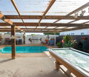 a patio with a swimming pool and a pergola at Honnehokke Resort in Hondeklipbaai