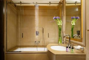 a bathroom with a sink and a shower with purple flowers at Hotel Balestri - WTB Hotels in Florence
