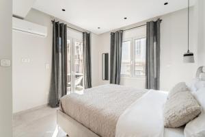 a white bedroom with a large bed and windows at Luna Luxury Suite - close to Acropolis in Athens +6 photos