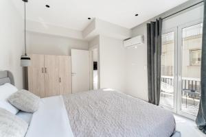 a bedroom with a bed and a large window at Luna Luxury Suite - close to Acropolis in Athens