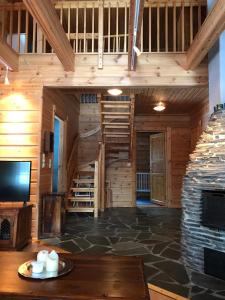 Cabaña de madera con TV y sala de estar en Pyrypolku 6, en Ruka