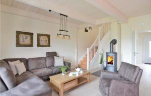 a living room with a couch and a fireplace at Nice Home In Dagebüll With Sauna in Dagebüll