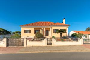 a house with an orange roof and a fence at Beautiful Deluxe Villa 4 Bedroom in Aldeia de Brescos