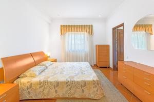 a bedroom with a bed and a dresser and a mirror at Beautiful Deluxe Villa 4 Bedroom in Aldeia de Brescos +22 photos