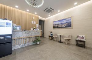 a lobby with a counter and a table and chairs at Hotel Haru in Seogwipo