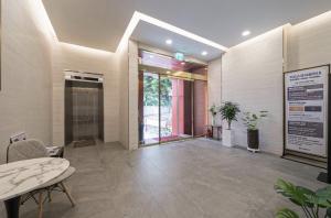 a lobby with a hallway with a table and chairs at Hotel Haru in Seogwipo