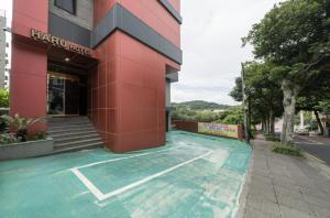 a building with a tennis court in front of it at Hotel Haru in Seogwipo