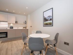 a dining room with a table and chairs and a kitchen at Sophisticated Apartment with Parking Central Slough in Slough