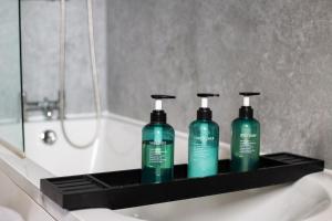 tres botellas de jabón en una estantería negra en un baño en Wellington Terrace, Private Garden, en Moreton-in-Marsh 14 fotos más