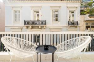 a table and chairs on a balcony with a building at Honey Luxury Suite - close to Acropolis in Athens +2 photos