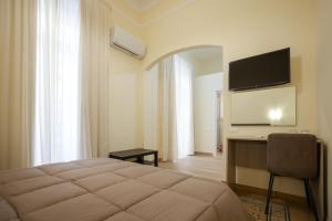 a bedroom with a bed and a desk with a television at B&B Salerno Stay in Salerno