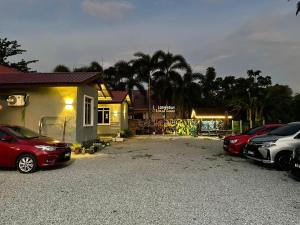 a parking lot with cars parked in front of a building at Laman Hanaz in Pantai Cenang