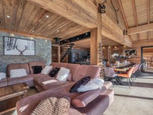 un soggiorno con divani marroni e una sala da pranzo di Chalet Mitoyen LA SAPINETTE - Bo Immobilier - remises sur les forfaits de skis Châtel ou Portes du soleil a Châtel