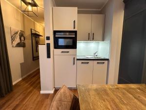 a small kitchen with white cabinets and a table at 4Hafenzeiten - NIE13 Eva in Niendorf