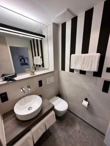 a bathroom with a sink and a toilet and a mirror at 4Hafenzeiten - NIE13 Eva in Niendorf