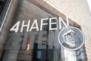a sign in the window of a store with a man at 4Hafenzeiten - NIE13 Eva in Niendorf +5 photos