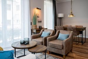 a living room with two chairs and a table at 4Hafenzeiten - NIE2 Heimat in Niendorf +15 photos