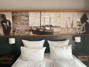 a bedroom with a bed with a picture of a boat at 4Hafenzeiten - NIE1 Lucie in Niendorf