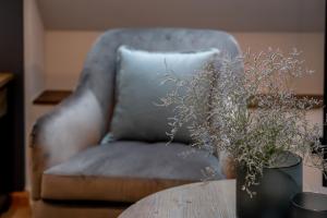 a blue chair with a table and a vase with a plant at 4Hafenzeiten - NIE1 Lucie in Niendorf