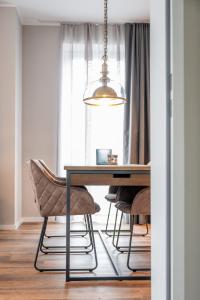 a dining room table with chairs and a light fixture at 4Hafenzeiten - NIE4 Else in Niendorf