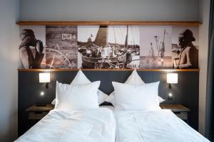 two beds in a room with pictures on the wall at 4Hafenzeiten - NIE4 Else in Niendorf