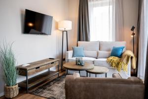 a living room with a couch and a table at 4Hafenzeiten - NIE4 Else in Niendorf +9 photos