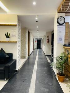 a hallway with a clock on the wall and a couch at Dream Suites Hotel in Hyderabad