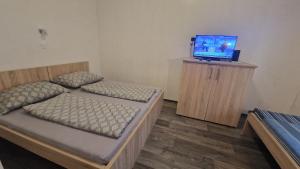 a bedroom with two beds and a tv on a wooden cabinet at Bem Downtown Apartment in Debrecen