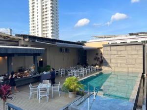 a hotel with a swimming pool and tables and chairs at Karon Boutique in Karon Beach