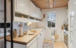 cocina con armarios blancos y techo de madera en Cozy Home In Haderslev With Wifi, en Haderslev