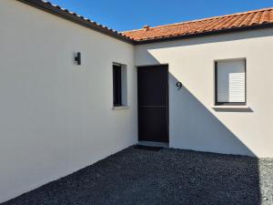 a garage with a black door and a building at Maison La Verrie 6/8 pers proche Puy du Fou in La Verrie +24 photos