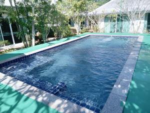 a swimming pool in a backyard with blue water at December To Remember House in Chachoengsao