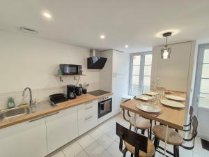 eine Küche mit einem Tisch und Stühlen in einer Küche in der Unterkunft Maison de Bourg St Amand 5pers 15min Puy du Fou in Saint-Amand-sur-Sèvre