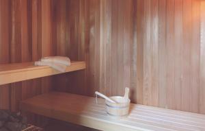 a sauna with a bucket and towels on a shelf at Gorgeous Home In Dagebüll With Sauna in Dagebüll
