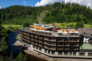 an aerial view of a hotel on a river at Sackmann Schwarzwald Charme in Baiersbronn +104 photos