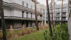 ウェバにあるNadmorska Florina, Sun & Snowの手前に木々が植えられたアパートメントビル