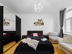 a bedroom with a bed and a couch and a chandelier at Three-Bedroom Sanctuary, King-Size Beds in Vienna